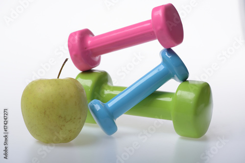 Apple fruit and pink, green and blue barbells