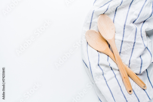 Wooden spoons and kitchen towel on white background
