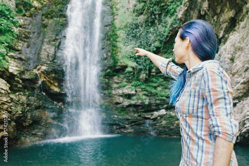 Woman pointing at waterfall.
