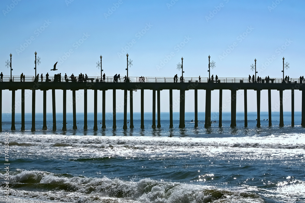 silhouette of people on an ocean pier on a sunny day