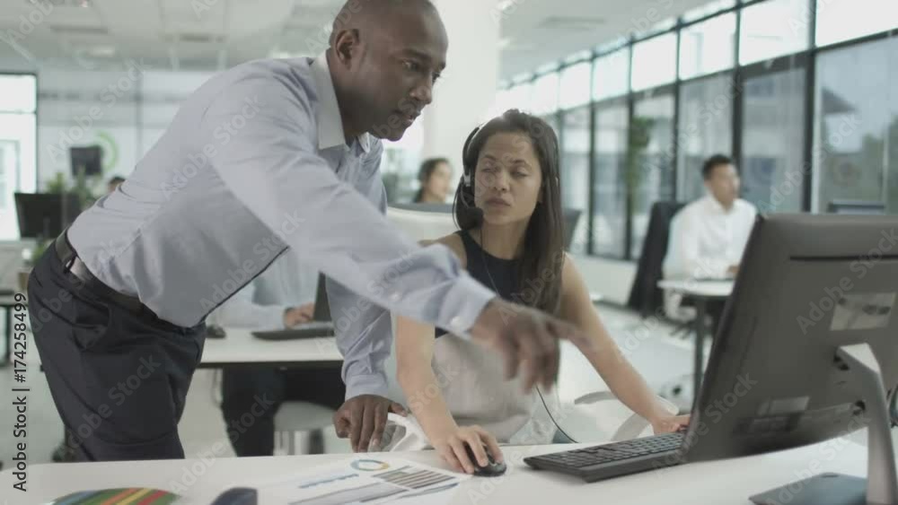 Manager watching over employees in financial services call center