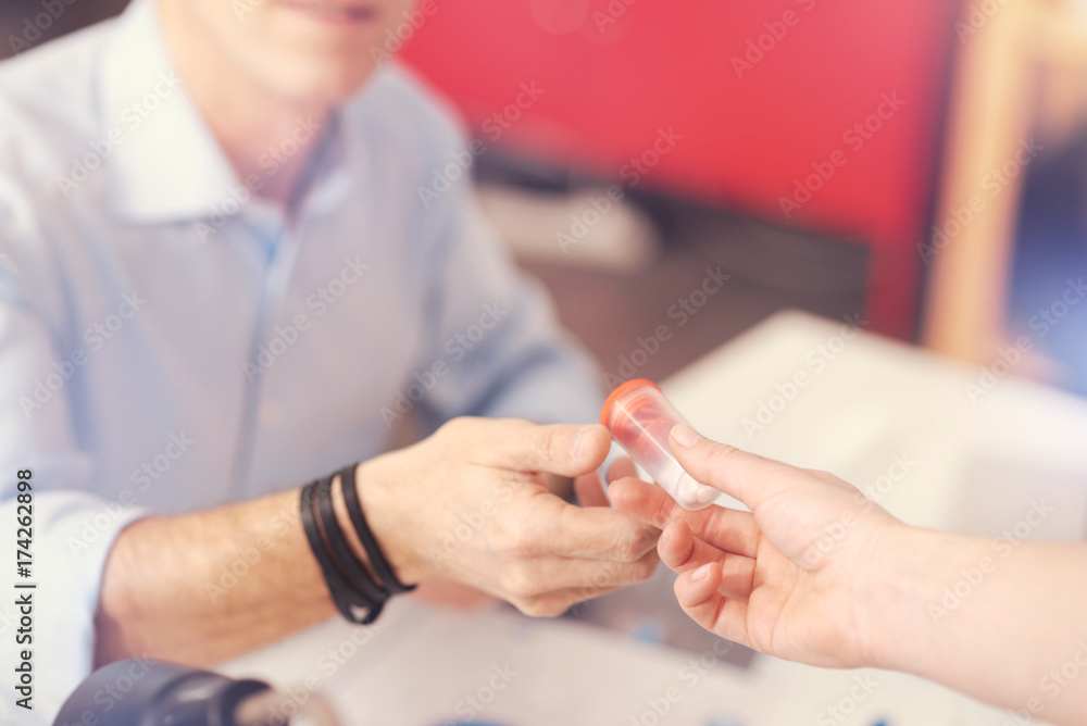 Pleasant person giving pills to a sick office worker