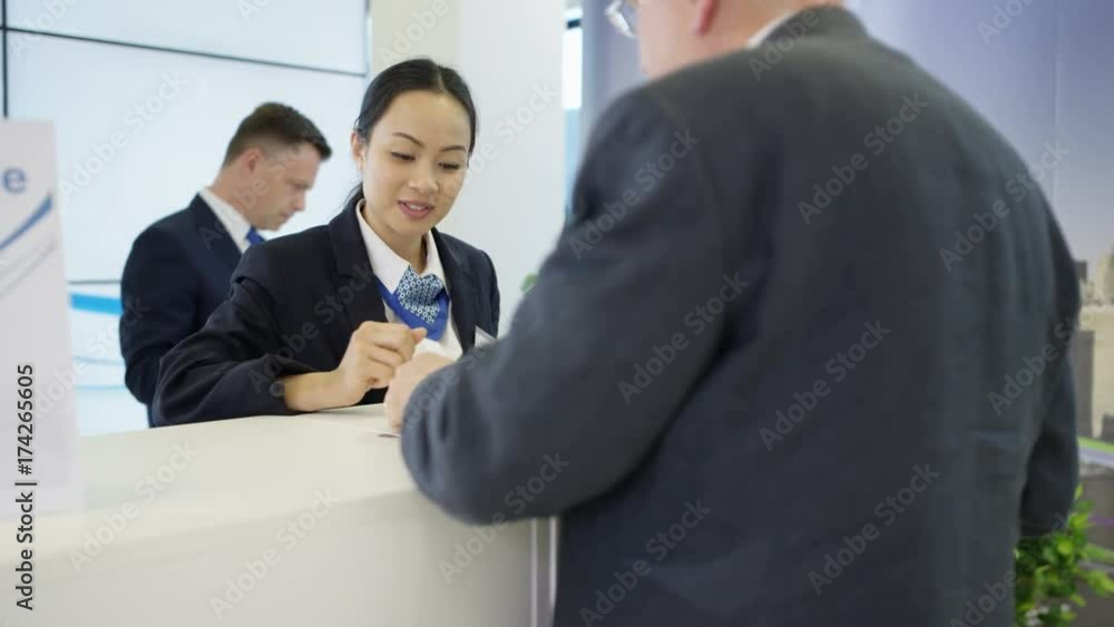 Bank worker at service desk taking cash deposit from a customer Bank worker at service desk taking cash deposit from a customer
