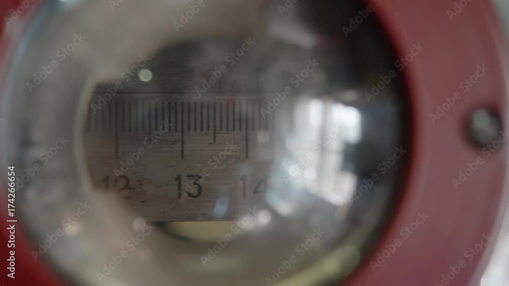Measuring ruler of old machine is moving in opposite direction. View through lens Measuring ruler of old machine is moving in opposite direction. View through lens