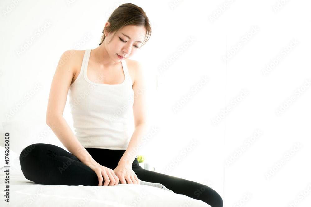 Fototapeta premium Asian beauty woman have a ankle ache in white bedroom