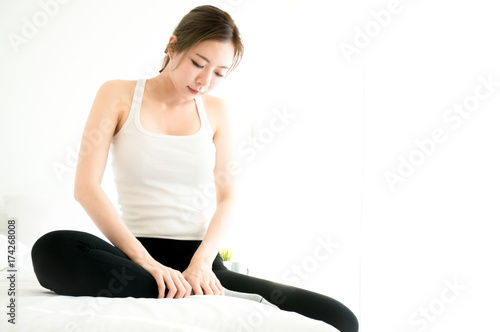 Asian beauty woman have a ankle ache in white bedroom photo