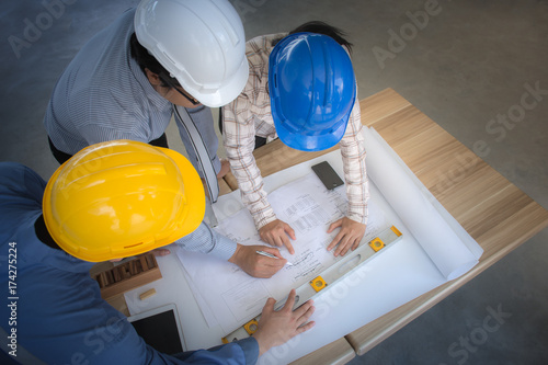 Engineering team is meeting, planning construction work, Engineer team looking paper plans at construction site,overhead view, Top view Concept for team work