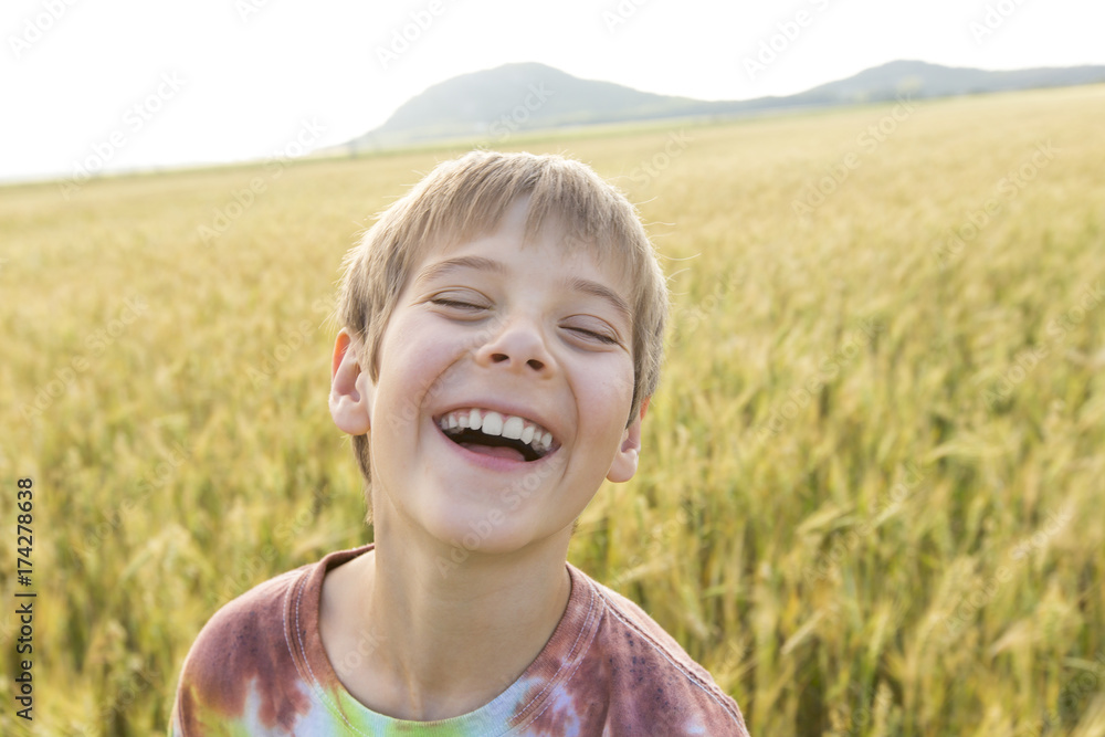 Adorable little boy playing in the wheat field on a warm summer day Adorable little boy playing in the wheat field on a warm summer day