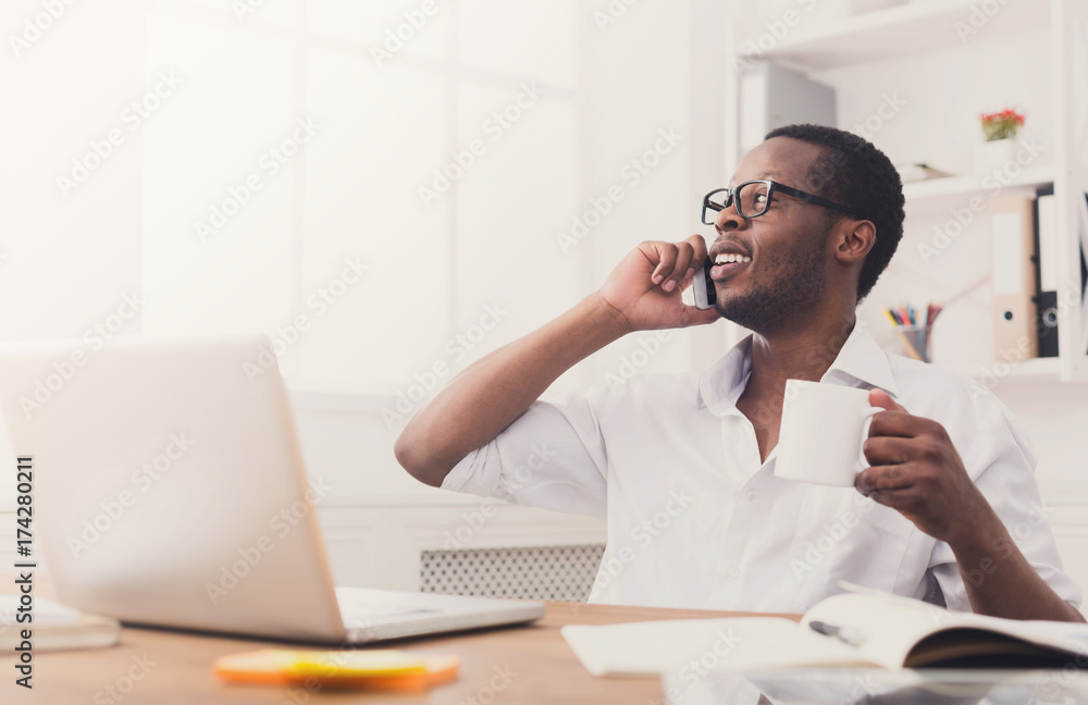 © Prostock-studio - Young black businessman call mobile phone in modern white office © Prostock-studio - Young black businessman call mobile phone in modern white office
