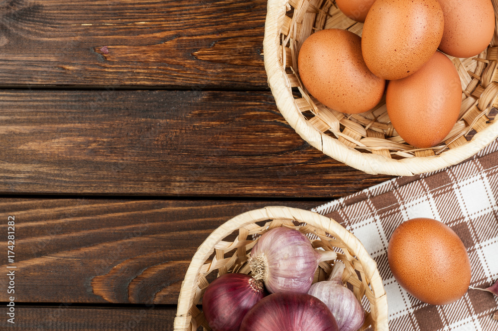 chicken eggs in basket decorated with food ingredients on wooden table