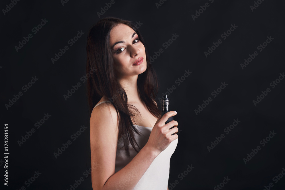 Young woman vaping e-cigarette on black Young woman vaping e-cigarette on black