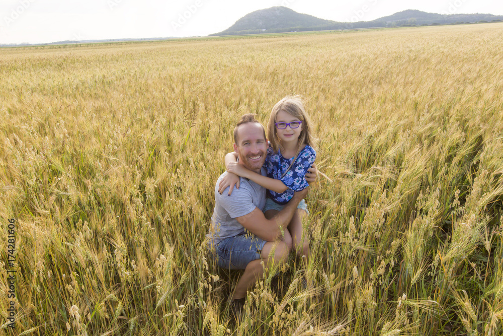 portrait of a father and daughter playing in the wheat field at sunset. portrait of a father and daughter playing in the wheat field at sunset.