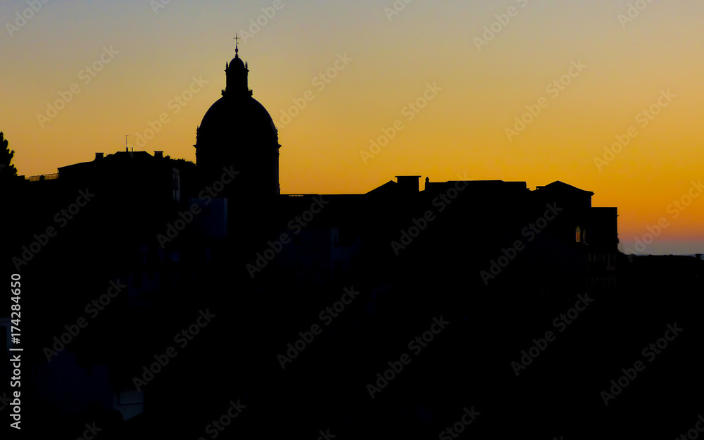 Silhouette of the National Pantheon dome against sunrise colors