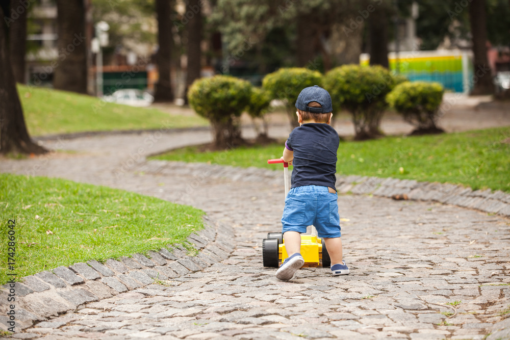 Fototapeta premium baby with a toy car in a park