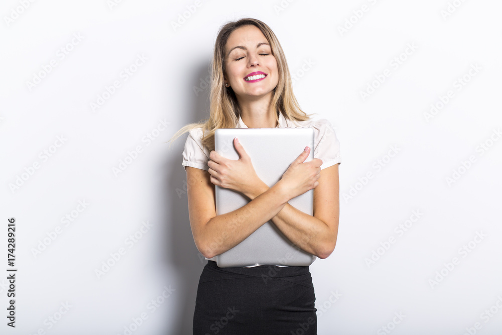 Young business woman offers computer product, on grey background Young business woman offers computer product, on grey background
