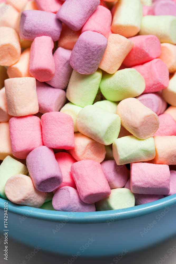 Colorful mini marshmallows in a blue bowl as background, macro. Fluffy marshmallows texture and pattern. High Resolution image, Soft focus Colorful mini marshmallows in a blue bowl as background, macro. Fluffy marshmallows texture and pattern. High Resolution image, Soft focus