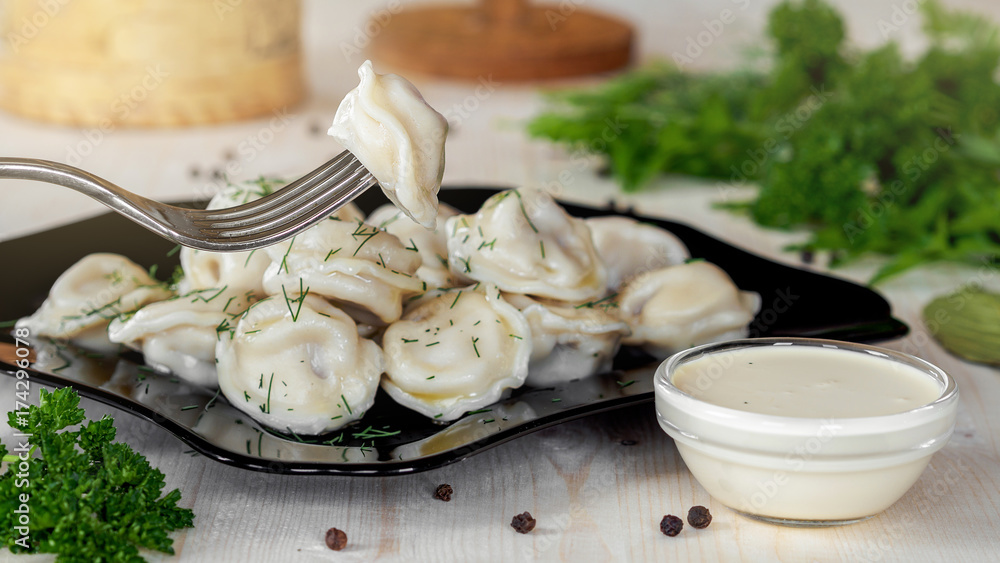 Meat dumplings - ravioli with meat on a black plate on a wooden background Meat dumplings - ravioli with meat on a black plate on a wooden background