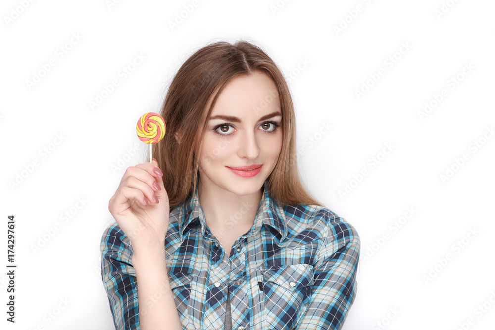 Beauty portrait of young adorable fresh looking blonde woman in blue plaid shirt posing with candy lollipop. Emotion and facial expression concept. Beauty portrait of young adorable fresh looking blonde woman in blue plaid shirt posing with candy lollipop. Emotion and facial expression concept.