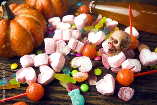 colorful of halloween candy with dessert on wood ground in party concept