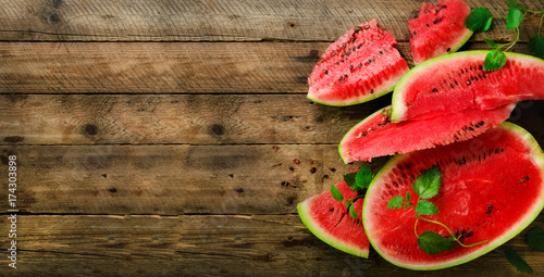 Slices of watermelon with mint leaves on wooden background. Detox and vegetarian concept. Top view, flat lay, copy space, banner