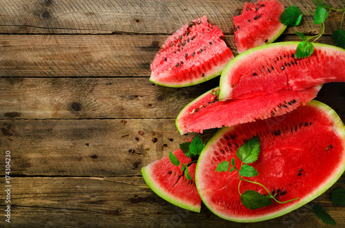 Slices of watermelon with mint leaves on wooden background. Detox and vegetarian concept. Top view, flat lay, copy space