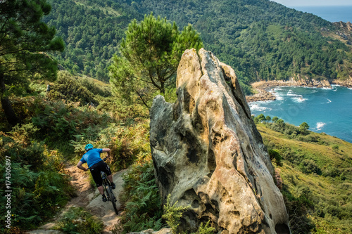 basque coast mountain biker riding along the coastal trail with sea and forest behind © Ian
