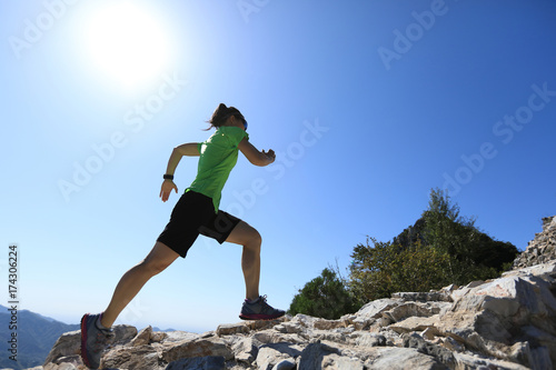 woman trail runner running at mountain top