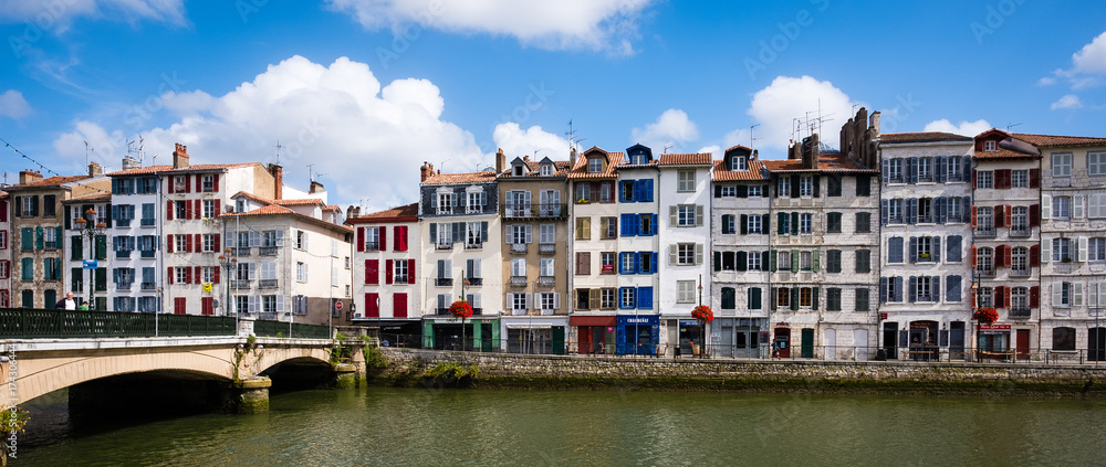 Old narrow houses in front of the river Adour, Bayonne, France