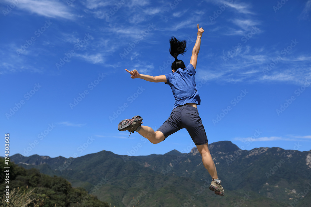 successful woman hiker jumping on mountain top successful woman hiker jumping on mountain top