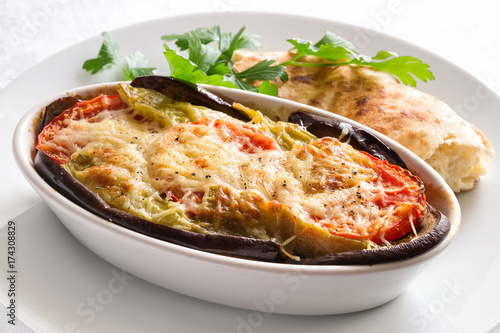 moussaka covered with grated cheese and served with pita bread and parsley