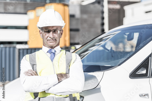 Senior builder man outdoors at construction site near his car lo