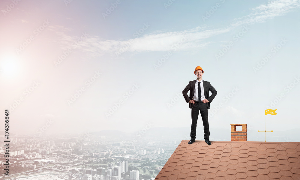 Engineer man standing on roof and looking away. Mixed media Engineer man standing on roof and looking away. Mixed media