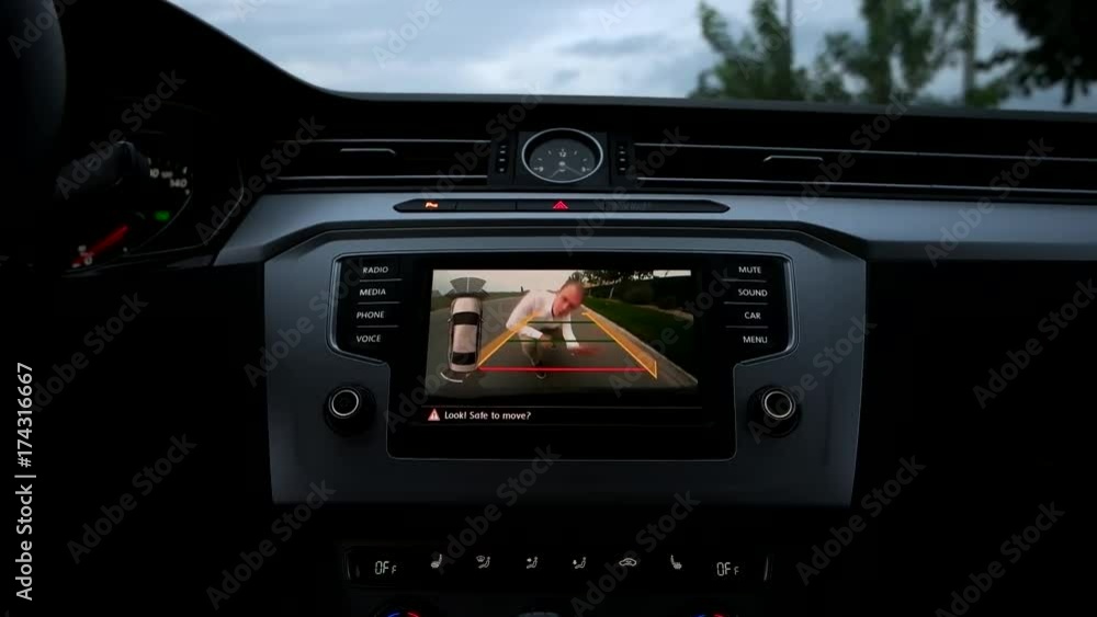 the guy waves into the car rear view camera. the guy waves into the car rear view camera.