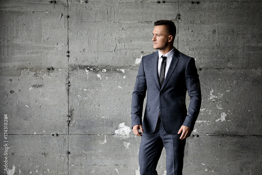 Portrait of stylish male dressed in a suit over grey background Portrait of stylish male dressed in a suit over grey background