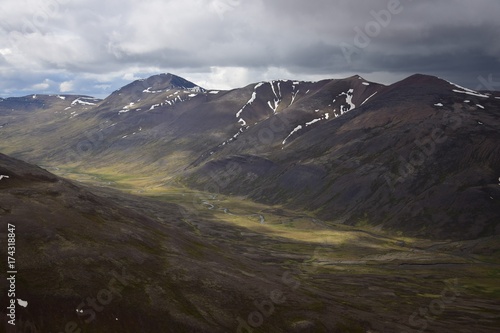 Sonne und Wolken in isl  ndischer Berglandschaft