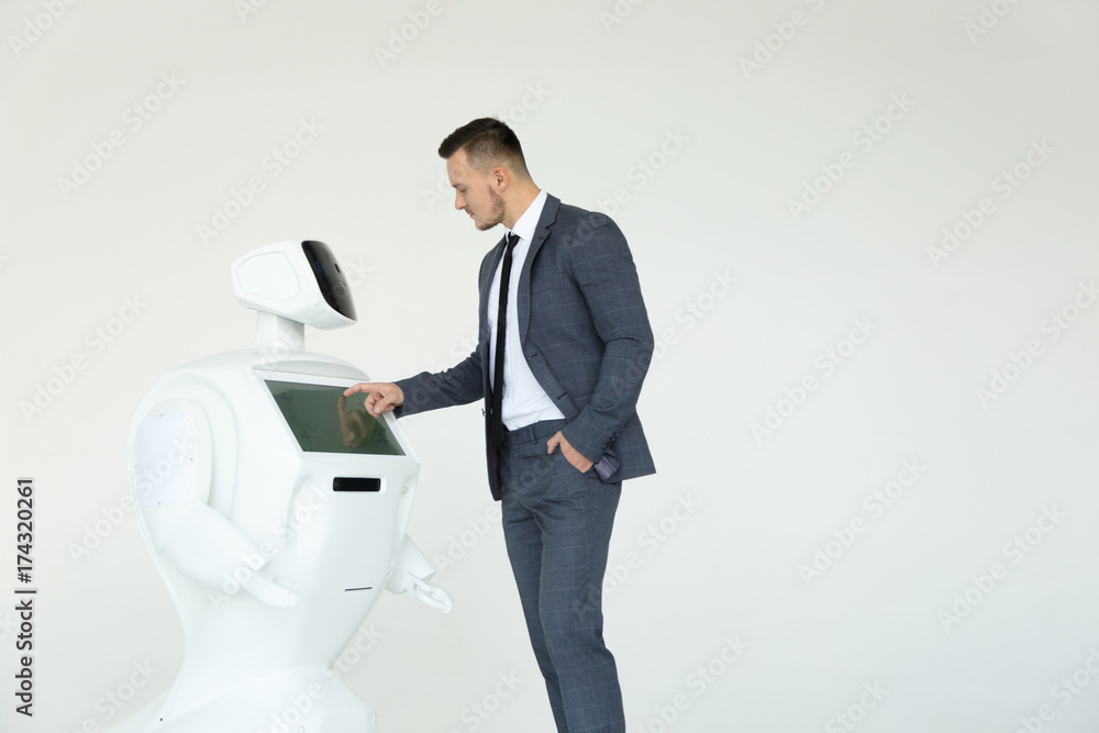 A stylish businessman communicates with a robot. Cybernetic system today. Modern Robotic Technologies. Humanoid autonomous robot. white background
