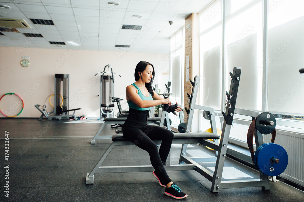 beautiful sports girl puts on gloves in the gym beautiful sports girl puts on gloves in the gym