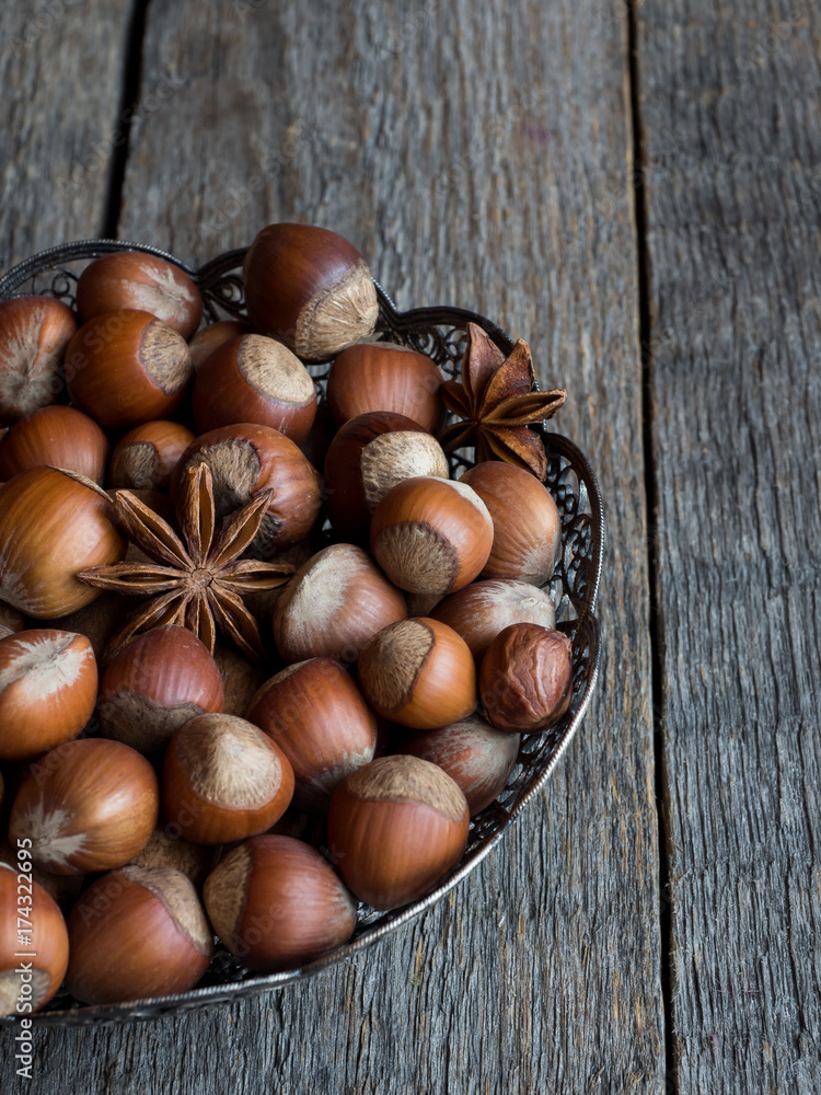 Obraz premium Hazelnuts in openwork plate on teriann background rustic