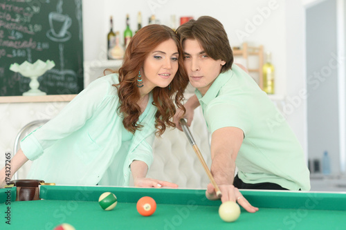 young couple playing billiard