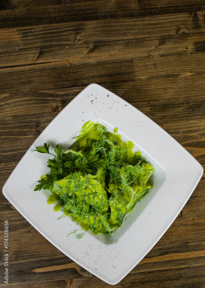 Green ravioli with spinach on a wooden background with copy space. top view Green ravioli with spinach on a wooden background with copy space. top view
