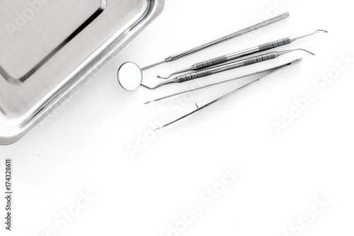 Set of dentists tools near cuvette on white background top view copyspace