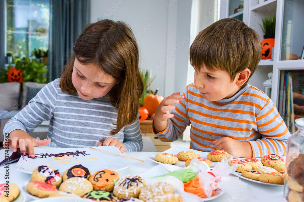 Children glazing cookies for Halloween celebration Children glazing cookies for Halloween celebration