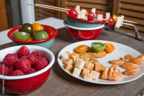 Snack idea - berry, tomato, crackers and cheese in enameled bowls