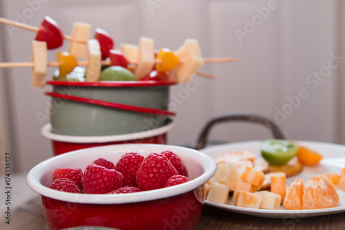 Snack idea, crackers, cheese, tomatoes, mandarin in enameled bowls 