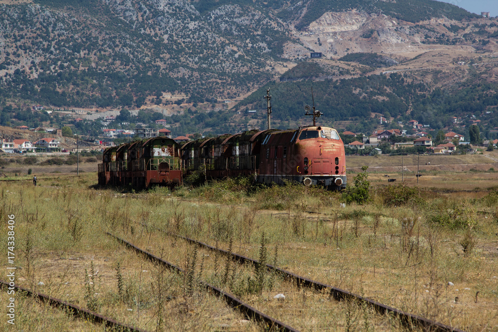 Old abandoned railway train rusting and decaying on the country side in Albania