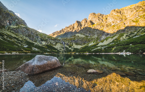 Mountain Lake with Rock in Foreground at Sunset photo