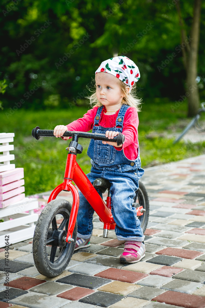 little girl riding her red bike little girl riding her red bike
