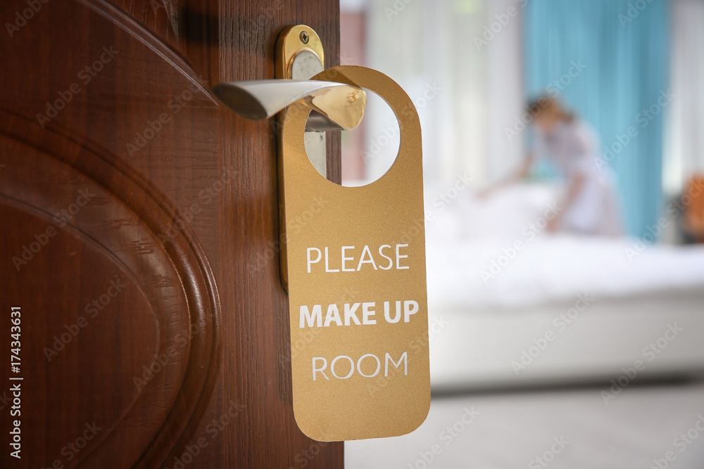 Obraz premium Open door with sign PLEASE MAKE UP ROOM on handle at hotel