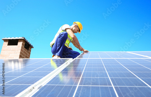 Worker installing solar panels outdoors