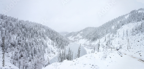 Beautiful lake Amut in taiga hills on Far East of Russia in early october. Mountain lake in winter. Beautiful nature. Snowy weather